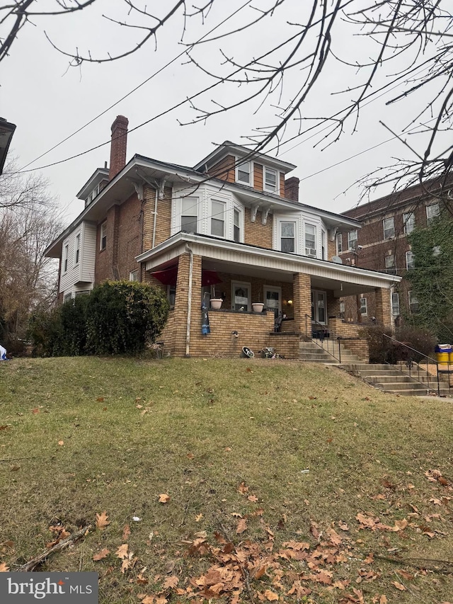 view of front of house featuring covered porch and a front yard