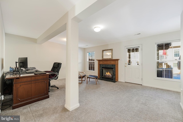 office with a wealth of natural light, light carpet, and a high end fireplace