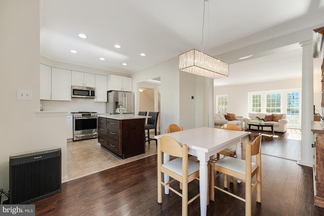 dining room with light wood-type flooring and crown molding