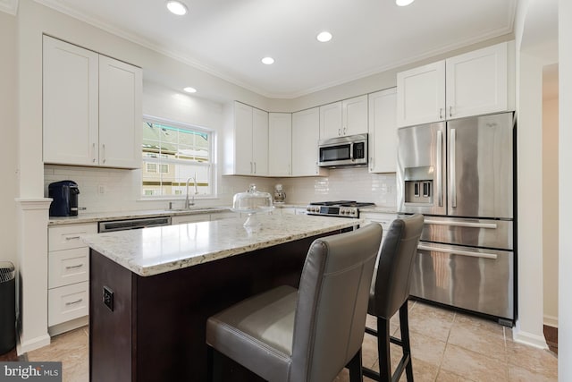 kitchen with white cabinets, a kitchen island, sink, and appliances with stainless steel finishes