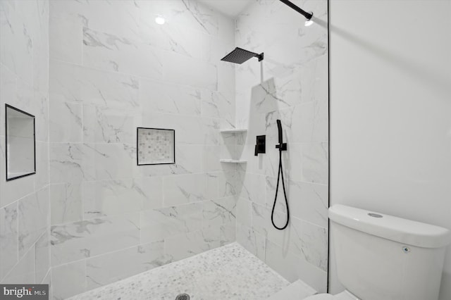 bathroom with toilet and a tile shower