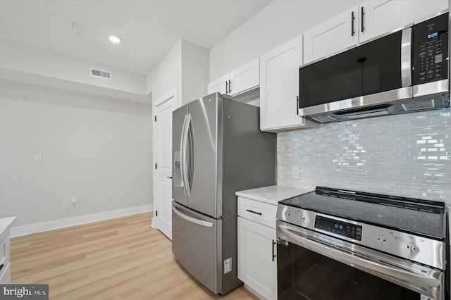 kitchen featuring decorative backsplash, light wood-type flooring, white cabinetry, and stainless steel appliances