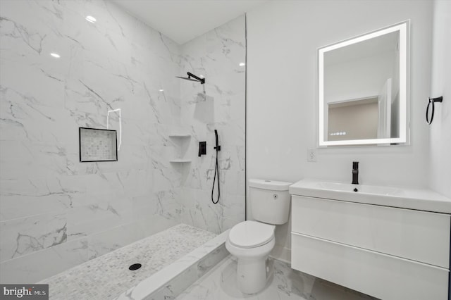 bathroom with vanity, toilet, and a tile shower