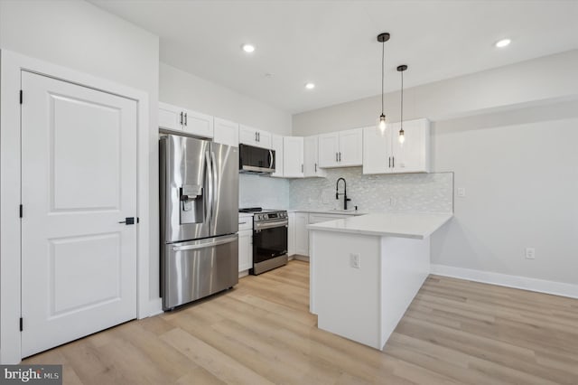 kitchen with sink, hanging light fixtures, appliances with stainless steel finishes, white cabinetry, and kitchen peninsula