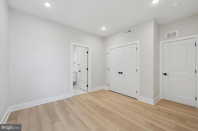 unfurnished bedroom featuring light hardwood / wood-style flooring and a closet