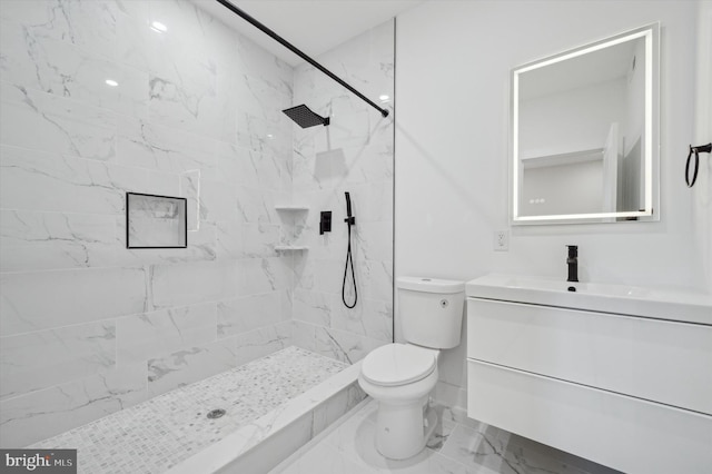 bathroom featuring tiled shower, vanity, and toilet