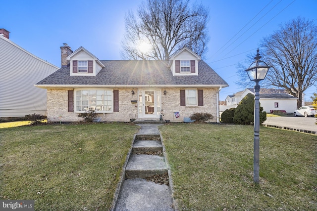 cape cod home featuring a front yard