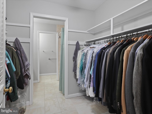 walk in closet with light tile patterned floors