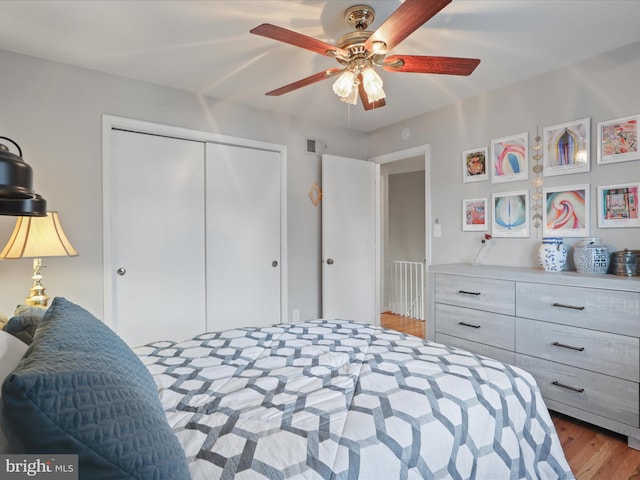 bedroom with ceiling fan, light hardwood / wood-style flooring, and a closet