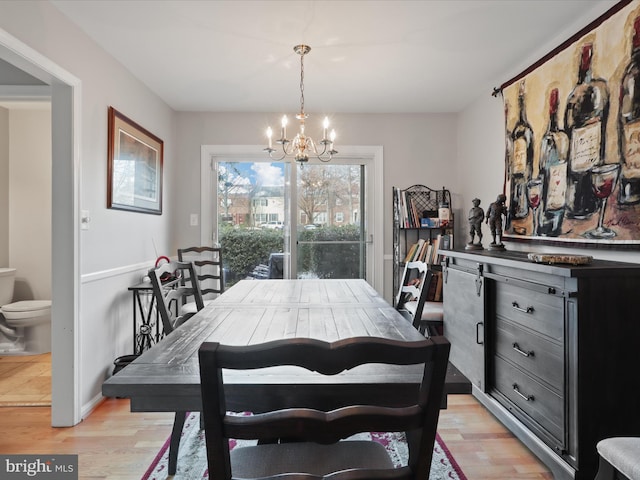 dining space featuring light hardwood / wood-style flooring and a notable chandelier