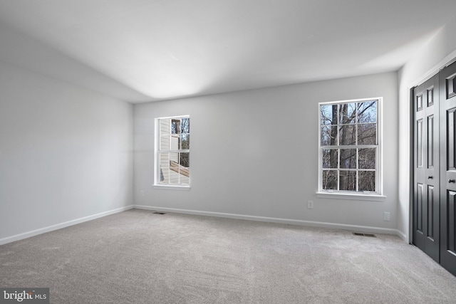 unfurnished room featuring plenty of natural light and carpet floors