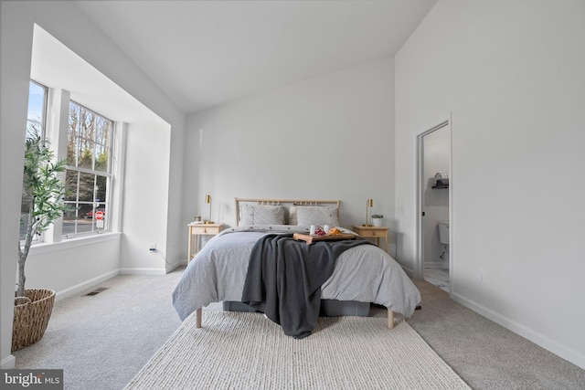 carpeted bedroom featuring multiple windows and lofted ceiling