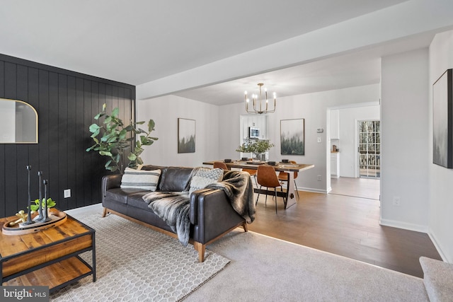 living room with a notable chandelier and wooden walls