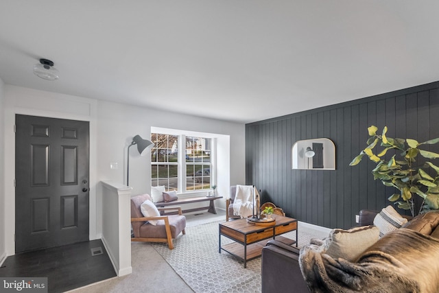 living room with carpet and wood walls