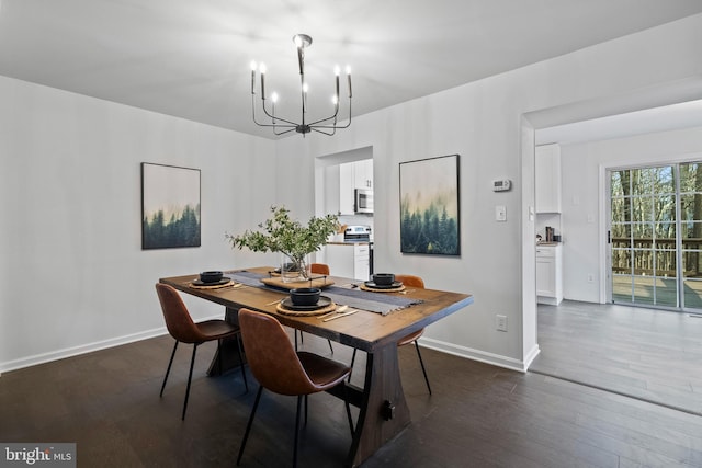 dining space with dark hardwood / wood-style flooring and an inviting chandelier