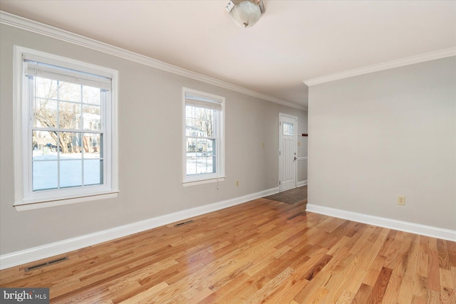 spare room with light hardwood / wood-style flooring and crown molding