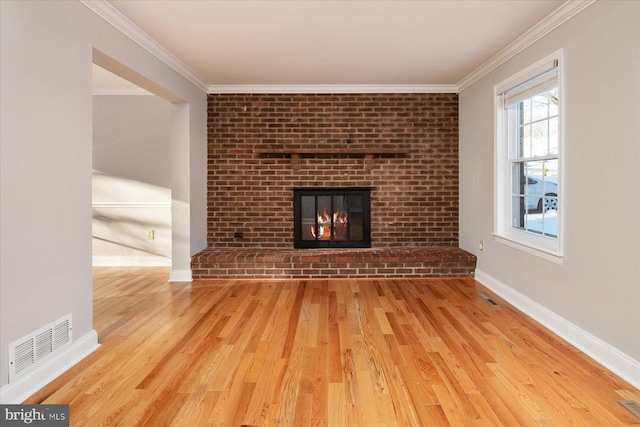 unfurnished living room featuring ornamental molding, a fireplace, and wood-type flooring