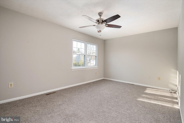 carpeted spare room featuring ceiling fan