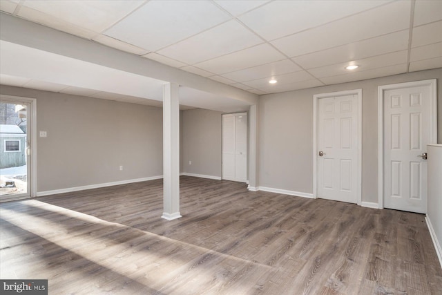 basement featuring hardwood / wood-style flooring and a paneled ceiling