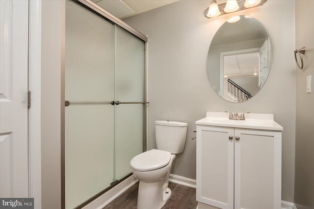 bathroom featuring a shower with door, hardwood / wood-style floors, vanity, and toilet