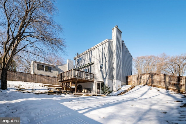 snow covered house with a deck