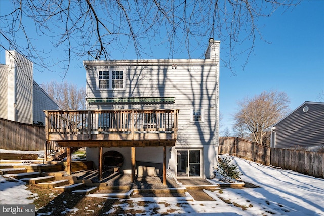 snow covered rear of property featuring a deck