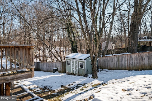 snowy yard featuring a storage unit