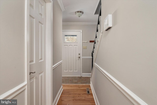 entryway with crown molding and light hardwood / wood-style flooring