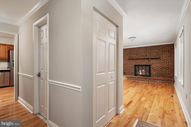 hallway featuring brick wall, light wood-type flooring, and ornamental molding