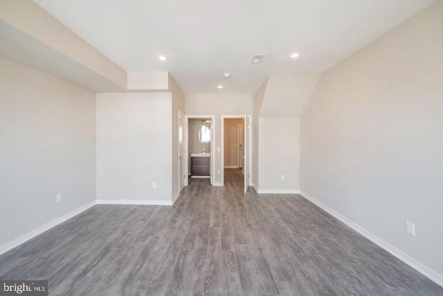 empty room featuring vaulted ceiling and dark hardwood / wood-style floors