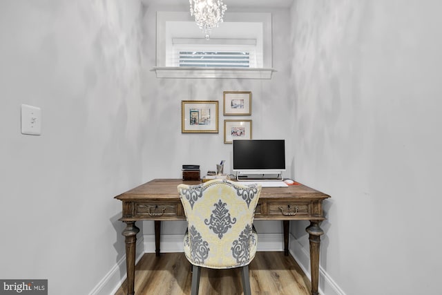 home office featuring hardwood / wood-style floors and a chandelier