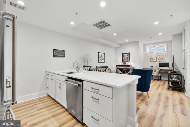 kitchen with kitchen peninsula, appliances with stainless steel finishes, light wood-type flooring, sink, and white cabinets