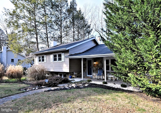 tri-level home with a patio and a front lawn