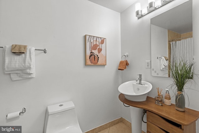 bathroom with tile patterned flooring, a shower with curtain, toilet, and sink