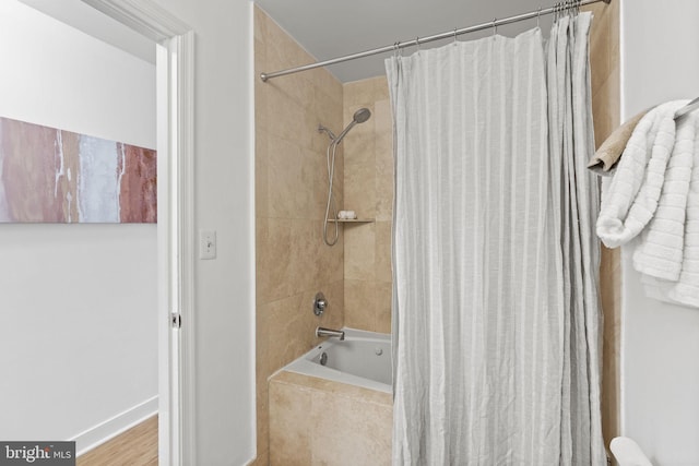 bathroom with hardwood / wood-style floors and shower / bath combination with curtain