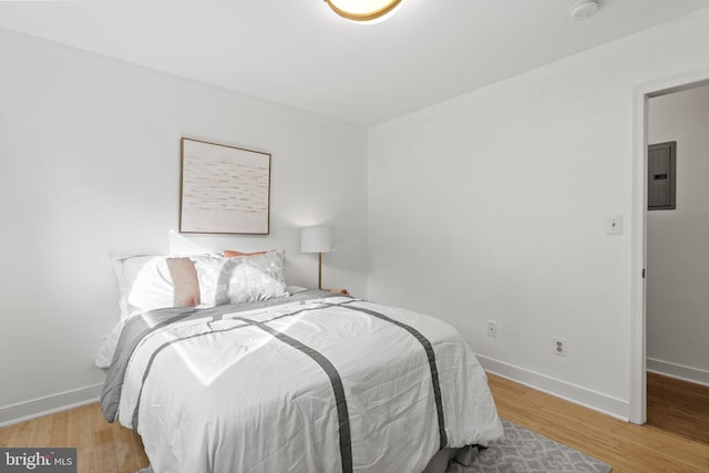 bedroom with light wood-type flooring and electric panel