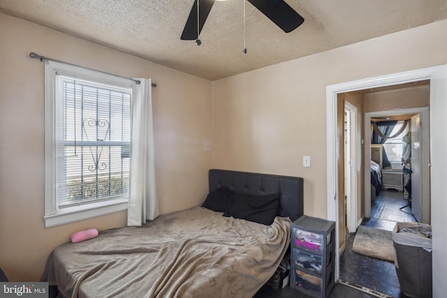 bedroom with ceiling fan and a textured ceiling