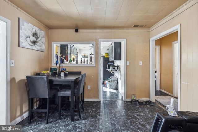 dining space with ornamental molding and bar area