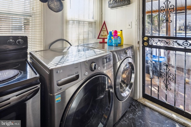 laundry room with washing machine and clothes dryer and plenty of natural light