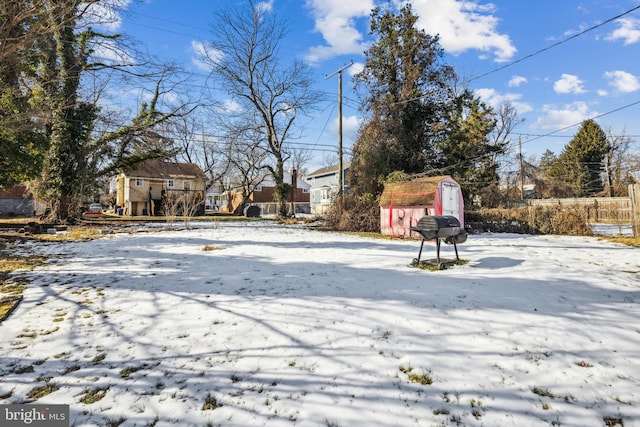 yard layered in snow with a storage shed