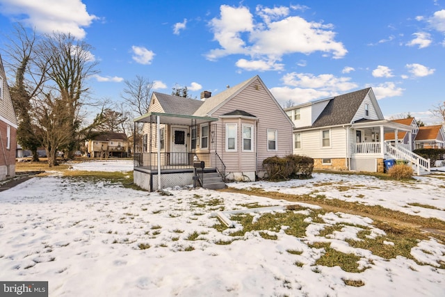 snow covered property with a porch