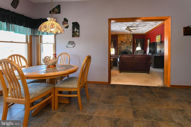 dining area with dark colored carpet and ceiling fan