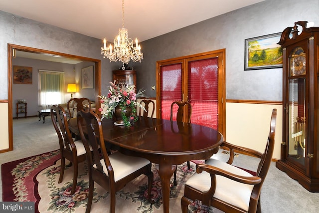 carpeted dining area with a notable chandelier