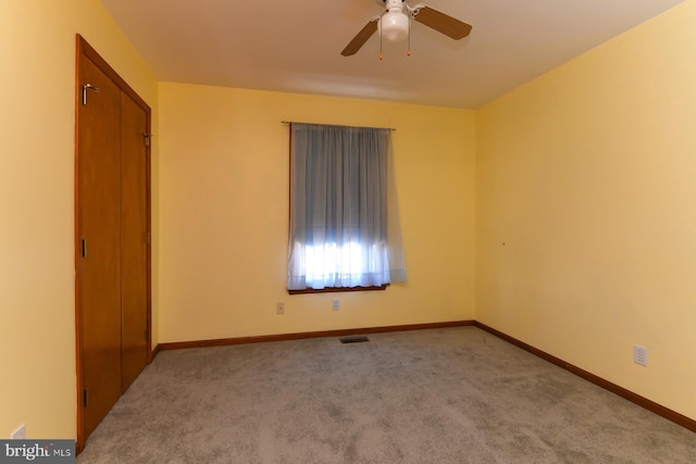 unfurnished room with ceiling fan and light carpet