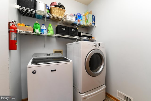 clothes washing area with washing machine and dryer