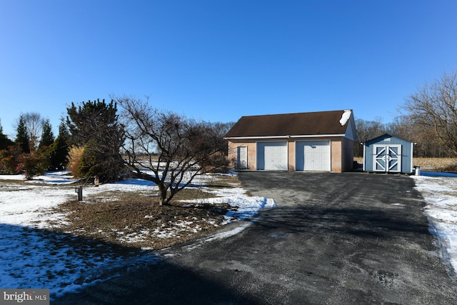 view of front of house featuring a garage and a storage shed