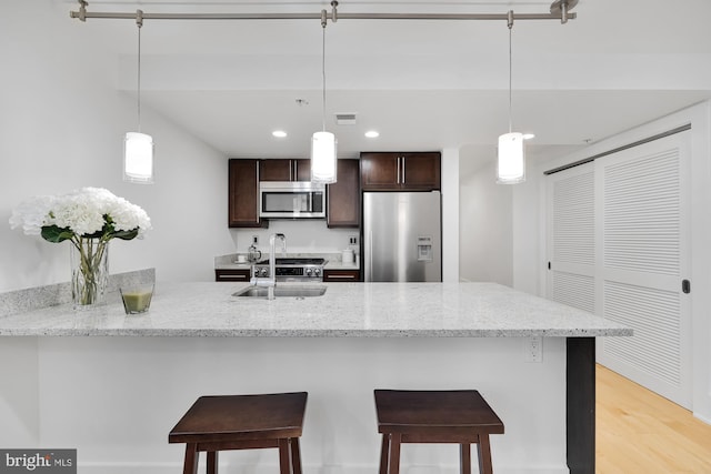 kitchen with decorative light fixtures, a kitchen breakfast bar, and stainless steel appliances