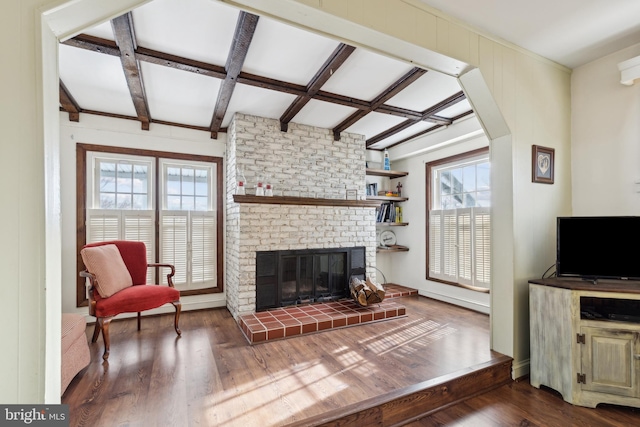 living room featuring plenty of natural light, beam ceiling, dark hardwood / wood-style floors, and a fireplace