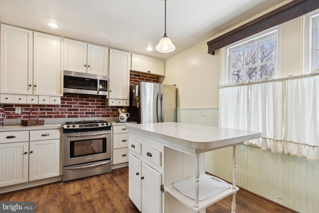 kitchen with pendant lighting, white cabinets, and appliances with stainless steel finishes