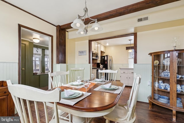 dining area with dark hardwood / wood-style flooring and crown molding